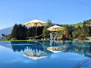 dos sombrillas sentadas en la parte superior de una piscina en Hotel Schloss Mittersill, en Mittersill