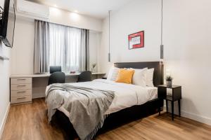 een slaapkamer met een bed, een bureau en een raam bij Au Piree by Calon in Piraeus