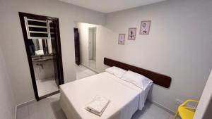 a small bedroom with a bed and a mirror at NORTH HOTEIS in Montes Claros