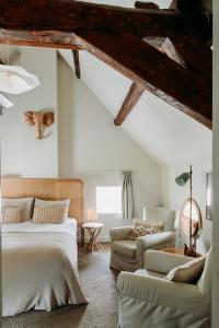 a bedroom with a bed and couches in a attic at Het Hart Van Alem in Alem