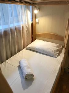 a white bed with a towel on top of it at Pelican Guest House & Hostel in Chernivtsi