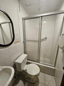 een badkamer met een douche, een toilet en een wastafel bij alborada cuenca hospedaje in Cuenca