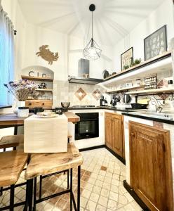 une grande cuisine avec une table en bois et une salle à manger dans l'établissement Hostdomus - Le Vigne sul Mare, à Pietra Ligure