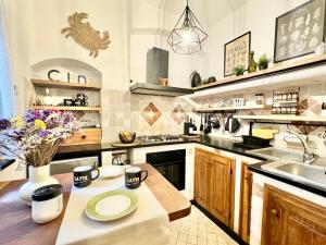 a kitchen with a table and a sink at Hostdomus - Le Vigne sul Mare in Pietra Ligure