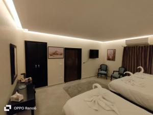 Habitación de hotel con 2 camas y TV en Alaaeldein pyramids Land inn en El Cairo