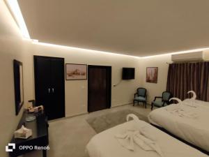 een hotelkamer met 2 bedden en een flatscreen-tv bij Alaaeldein pyramids Land inn in Caïro