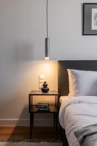 a bedroom with a bed and a table with a lamp at Au Piree by Calon in Piraeus