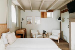 Alem的住宿－Het Hart Van Alem，一间卧室配有一张床和两把椅子
