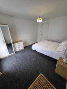 1 dormitorio con cama, tocador y espejo en 10 old church street en Cefn-coed-y-cymmer