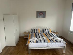 1 cama blanca en un dormitorio con una pared blanca en Apartmán Krkovička, en Mikulášovice