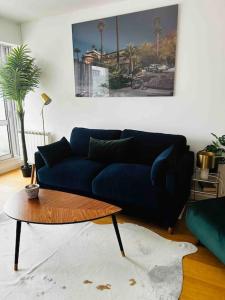 a living room with a blue couch and a coffee table at Le raffiné - Studio avec balcon, proche de l'océan in La Baule