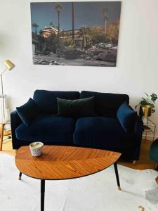 Sofá azul en la sala de estar con mesa de centro en Le raffiné - Studio avec balcon, proche de l'océan, en La Baule
