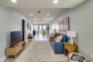 uma sala de estar com um sofá azul e uma televisão em Bayfront Maryland Retreat with Deck, Near Beaches! em North Beach
