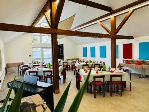 a dining room with tables and chairs in a building at Haus Rosenbaum am Rennsteig Gruppenhaus - Pension - Ferienhaus bis 50 Personen in Neuhaus am Rennweg