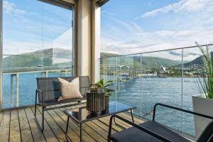 a balcony with a view of the water and mountains at TA Vervet- Fram in Tromsø