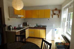 a kitchen with yellow cabinets and a stove top oven at APARTMA LINDAU in Lendava