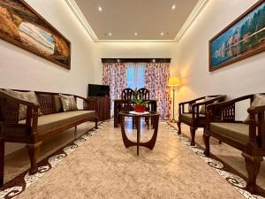 a living room with couches and a table at Leisure By The Beach Goa in Benaulim