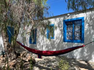 a red hammock hanging in front of a building at Cindy Se Huisie in Merweville in Merweville