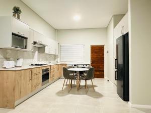 a kitchen with a table and a black refrigerator at Shamah in Pretoria