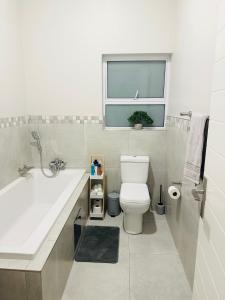 baño con lavabo y aseo y ventana en Shamah en Pretoria