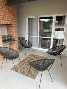 a patio with four chairs and a table and a grill at Shamah in Pretoria