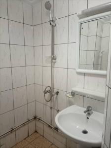 La salle de bains est pourvue d'un lavabo et d'une douche avec un miroir. dans l'établissement MAKO PALACE Hôtel, à Bafoussam