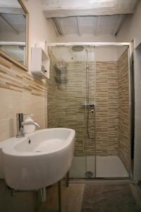 W łazience znajduje się biała umywalka i prysznic. w obiekcie Appartamento il Girasole w mieście Cetona
