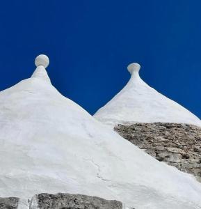 twee torens van een gebouw met sneeuw erop bij Trulli Dimora Florenzo in Selva di Fasano