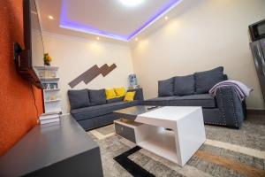 ein Wohnzimmer mit einem Sofa und einem Tisch in der Unterkunft Tegera Homes in Kericho