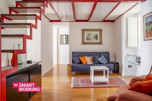 sala de estar con sofá azul y escaleras en Seaview Design Homes in Ortigia by Wonderful Italy en Siracusa