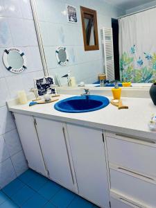 y baño con lavabo azul y espejo. en Descanso urbano, en Santiago