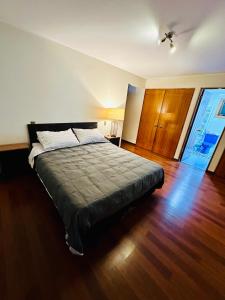 a bedroom with a bed and a wooden floor at Descanso urbano in Santiago