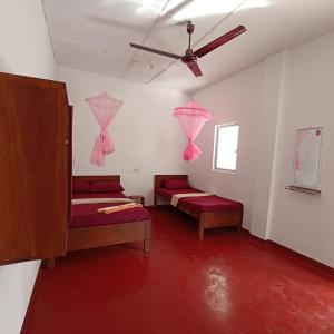 Pokój z 2 łóżkami i wentylatorem sufitowym w obiekcie DA GREA NATURAL BEACH HOTEL w mieście Trikunamalaja