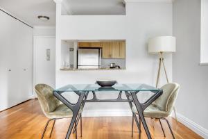 a dining room with a glass table and chairs at Midtown 1BR w DM Elevator Gym nr Times Sq NYC-799 in New York