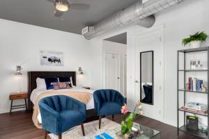 a bedroom with a bed and two blue chairs at The East View - Downtown - Steps to Dickson in Fayetteville