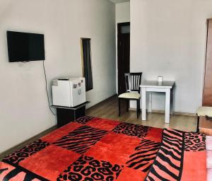 Habitación con mesa, TV y alfombra. en YAŞAR OTEL, en Mersin