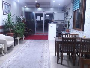 a living room with tables and chairs and a refrigerator at YAŞAR OTEL in Mersin