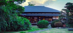 ein Gebäude mit einem Dach mit Büschen davor in der Unterkunft Antique Villa Lotus"bette" - Vacation STAY 16217 in Tsukuba