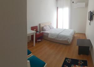Habitación pequeña con cama y escritorio. en YAŞAR OTEL, en Mersin
