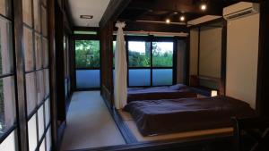 2 Betten in einem Zimmer mit 2 Fenstern in der Unterkunft Antique Villa Lotus"bette" - Vacation STAY 16217 in Tsukuba