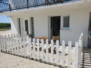 a white picket fence in front of a white house at La bastille 4 in Saintes