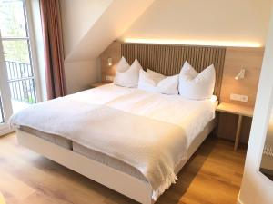 a bedroom with a large bed with white sheets and pillows at Hotel Zur Traube in Ürzig