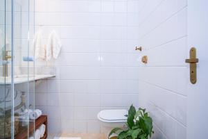 a bathroom with a toilet and a glass shower at Casa Hotel Sahy in Barra do Sahy