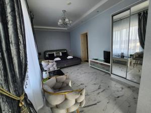 a bedroom with a bed and a chair and a mirror at Otel Apartments in Kyiv