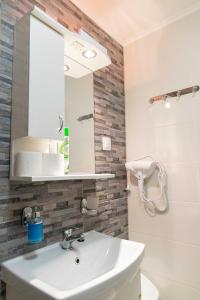 ein Bad mit einem Waschbecken und einem Spiegel in der Unterkunft Farkas Villa in Mórahalom