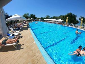 a large swimming pool with people in the water at Apartmani Omišalj in Omišalj