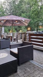 a patio with an umbrella and tables and benches at Fatrapark 2 Apartments House in Ružomberok