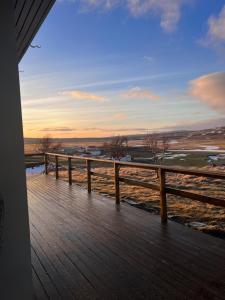 - une terrasse couverte en bois avec vue sur l'océan dans l'établissement Stóra-Ásgeirsá Horse Farm Stay, à Víðigerði