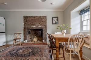 a living room with a table and a fireplace at No7 Drummond Street, 2 bedrooms, Comrie in Comrie