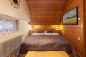 - une chambre avec un grand lit dans un mur en bois dans l'établissement Apartments Kot'č, à Kranjska Gora